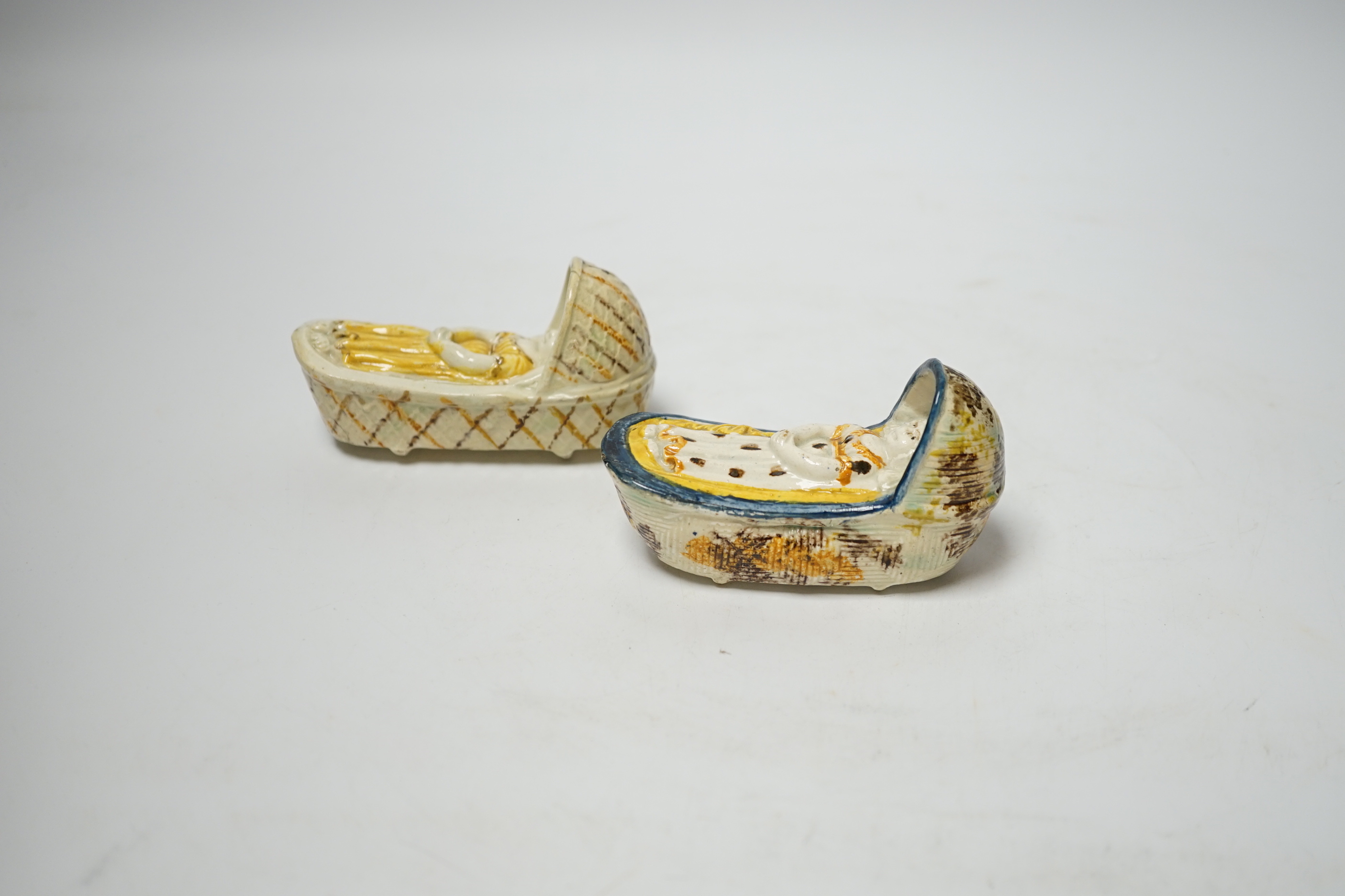 Two late 18th century Prattware ‘crib’ models of cradles, 10cm long